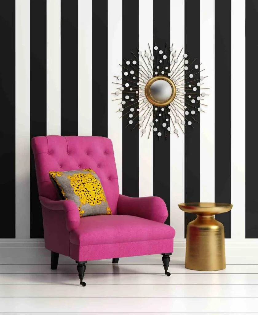 Bright pink chair in front of black and white stripe wallpaper