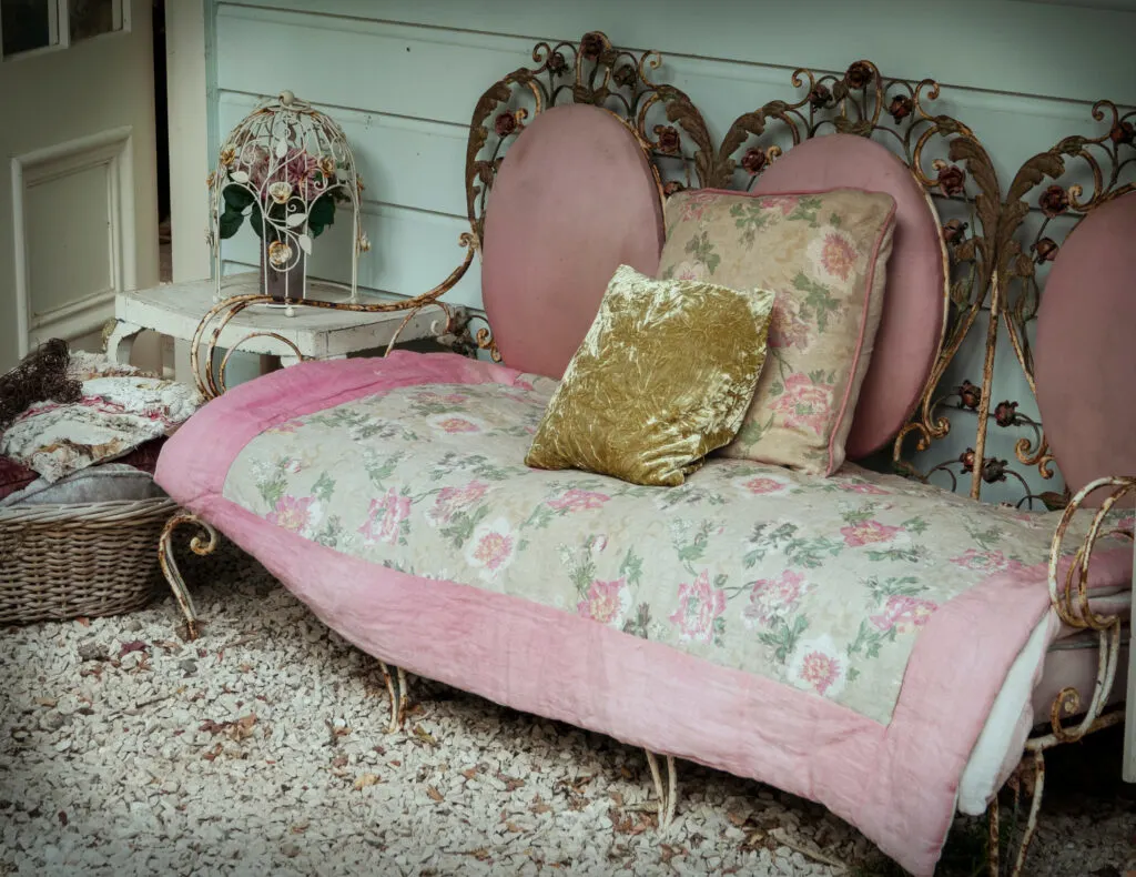 Vintage wrought iron sofa with pink and gold accents