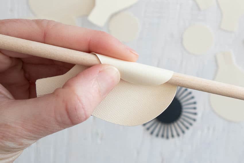cream paper flowers curled around pencil