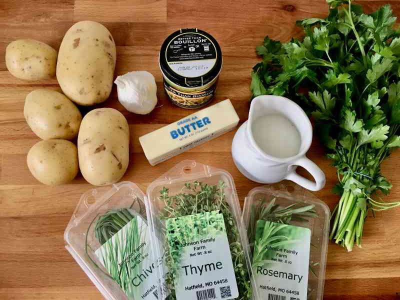 Garlic and herb mashed potatoes ingredients on a wooden countertop