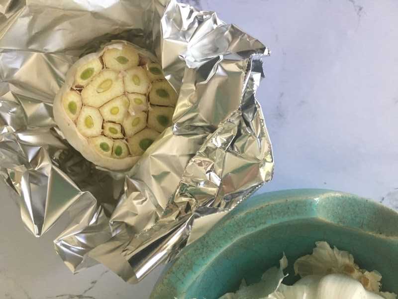 Head of garlic with top cut off, showing green-centered cloves
