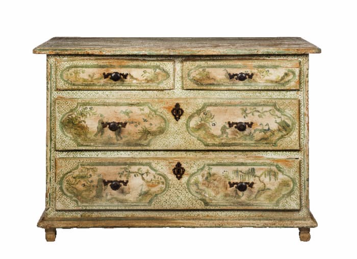 A painted dresser with painted tree murals on the fronts of the drawers.