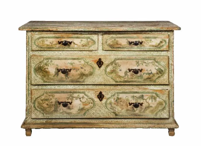 A painted dresser with painted tree murals on the fronts of the drawers.
