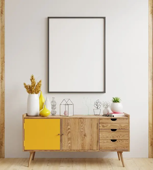 A wooden dresser with a single door painted golden yellow.