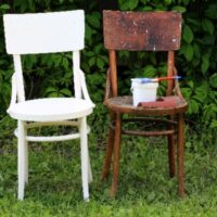 Two chairs representing before/after of a paint over stain project.