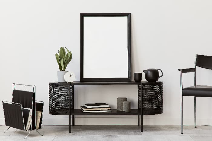 Black furniture decor -- chair, magazine stand, side table, and mirror.