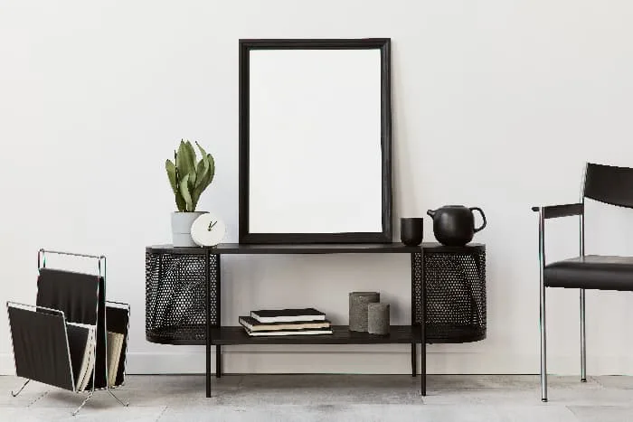 Black furniture decor -- chair, magazine stand, side table, and mirror.