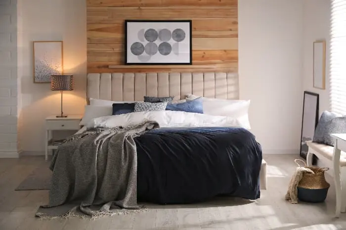 A bedroom with a blue comforter/bedspread, along with various blue accessories -- bedding and accessories can be a decorating alternative to blue furniture pieces.