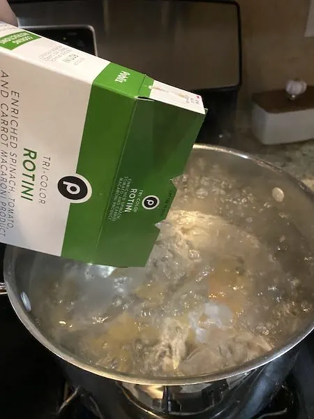 Cooking the pasta in boiling salted water.