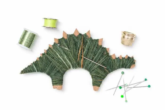 Dinosaur craft -- cardboard dinosaur wrapped in green wool.