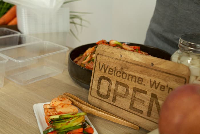 A modern-style light colored wooden farmhouse kitchen sign with 
