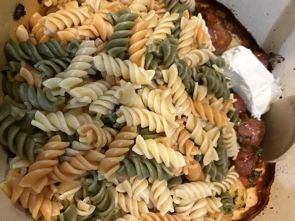 Mixing the baked feta pasta ingredients in dutch oven.