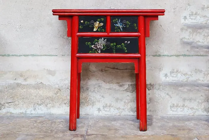 A Chinese-style painted table with a red lacquered paint job.