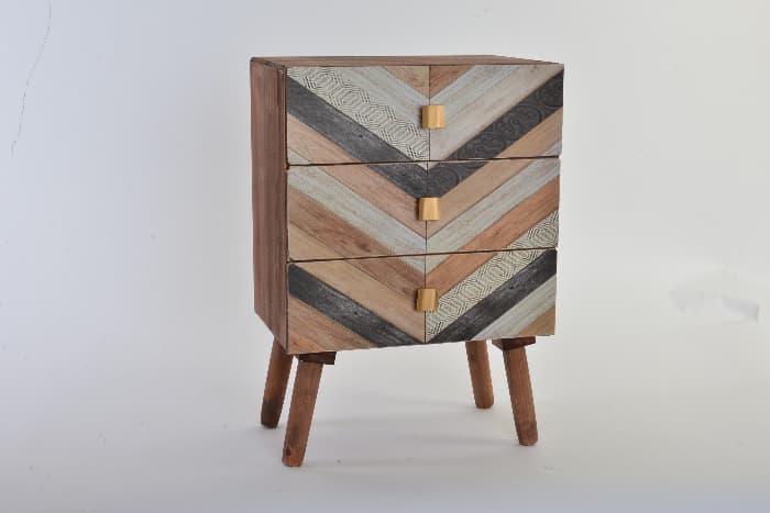 A small cupboard that has been painted to look like wood inlay in a chevron pattern -- an idea for a painted table project.