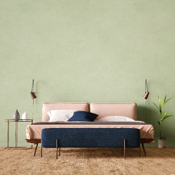 Bedroom with pale green walls, modern furniture in pale lilac and dark lilac colors, and bare wood floors.