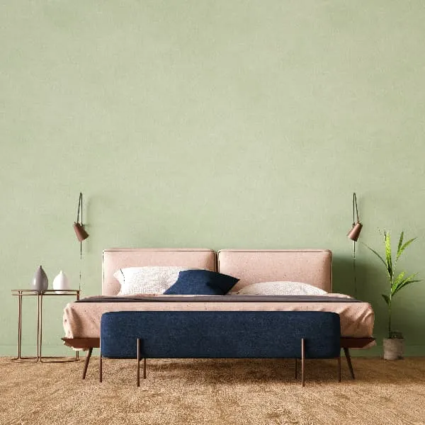 Bedroom with pale green walls, modern furniture in pale lilac and dark lilac colors, and bare wood floors.