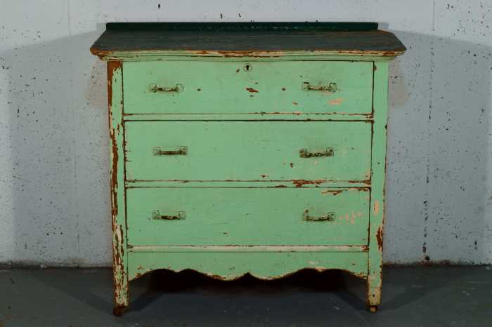 A dresser painted in green chalk paint with a distressed finish.