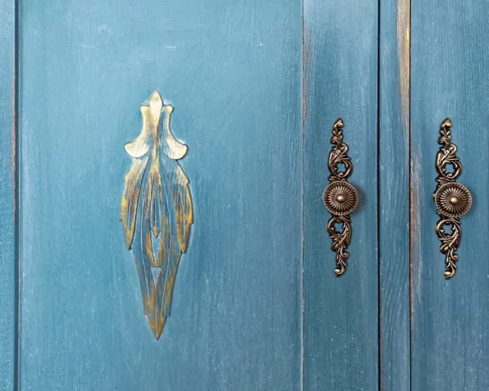 Closeup of cabinet doors painted in a rustic or farmhouse style.