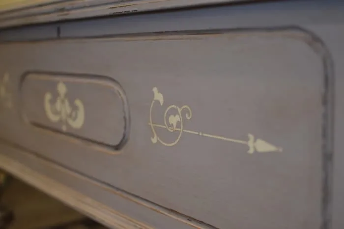 Closeup of a cedar chest painted with gray chalk paint and stenciled with a design