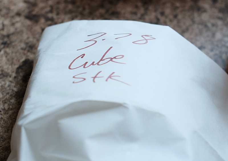 Cube steak wrapped in white butcher paper with "3.78 Cube Stk" written on it.