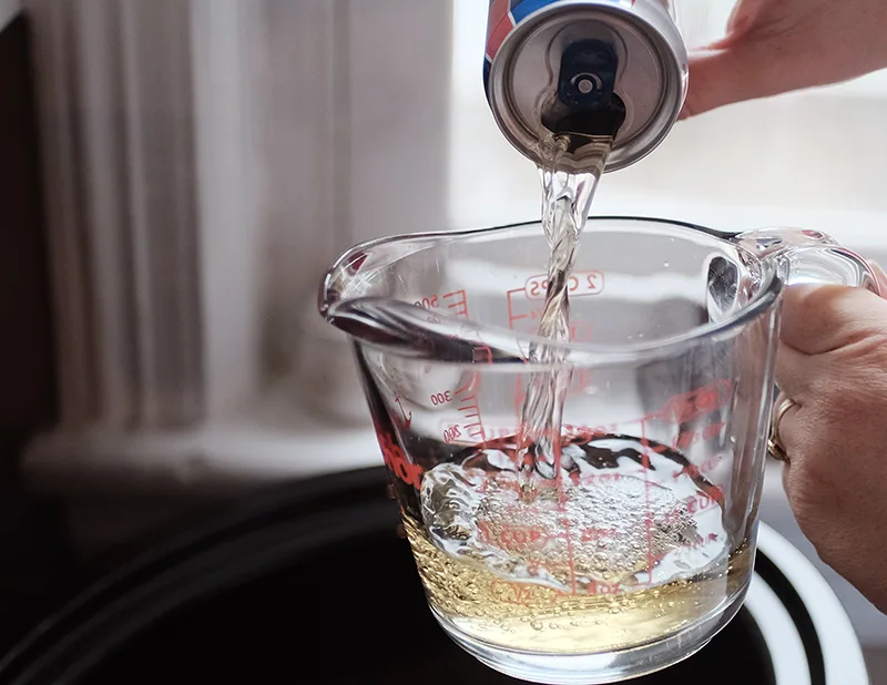 Beer being poured into large glass measure.