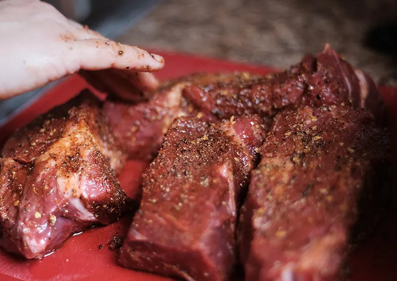 Chuck roast pieces seasoned with spices.