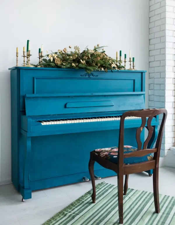 An upright piano painted blue.
