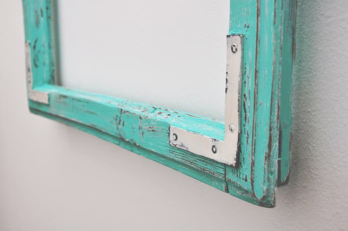 Closeup of bottom edge of painted picture or cabinet frame with distressing.  When you know how to chalk paint furniture, you can apply that knowledge other paint projects.