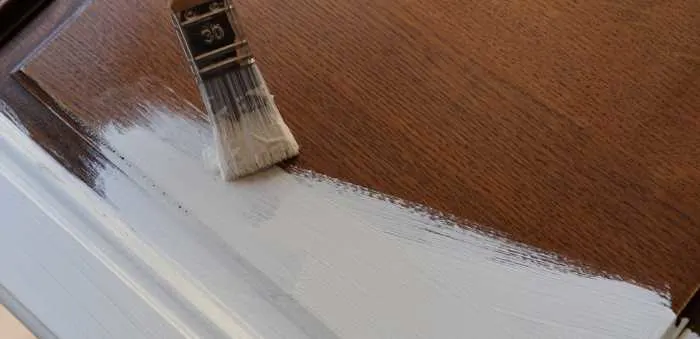 dark brown kitchen cabinet doors being painted with white chalk paint