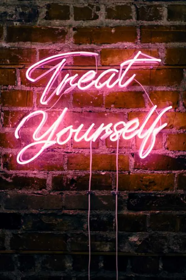 pink neon sign that says "Treat Yourself"