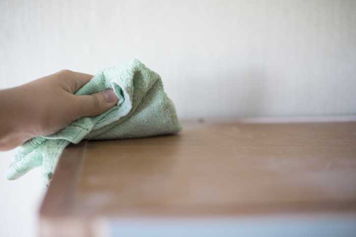 dusting furniture with a cloth
