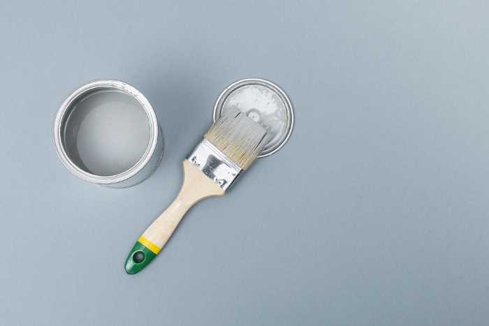can pf gray chalk paint with a paint brush beside it. 