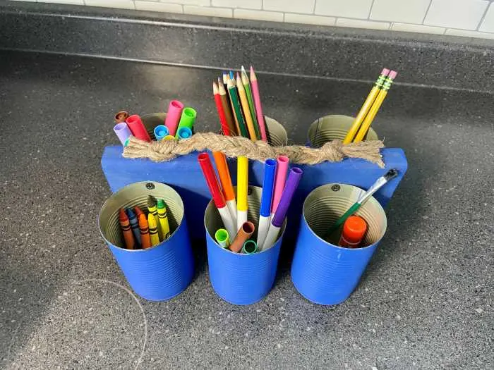 tin can utensil holder with craft supplies in it.