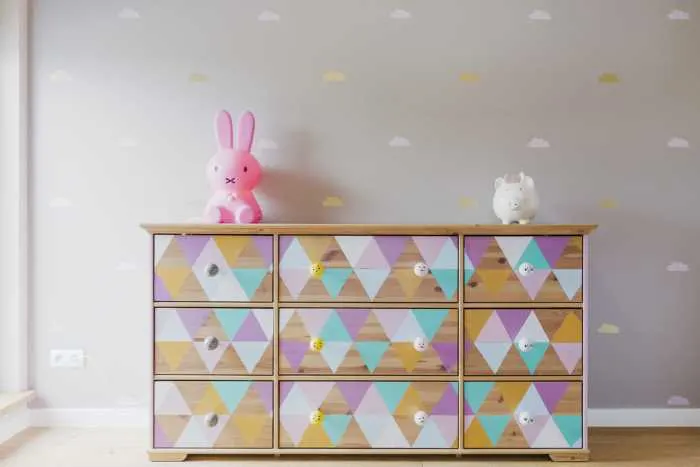 painted dresser with multicolored triangles in a child's nursery