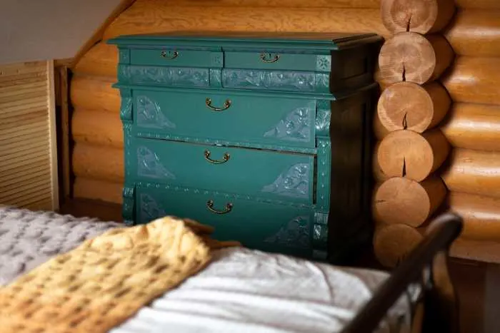 teal painted dresser in a log cabin