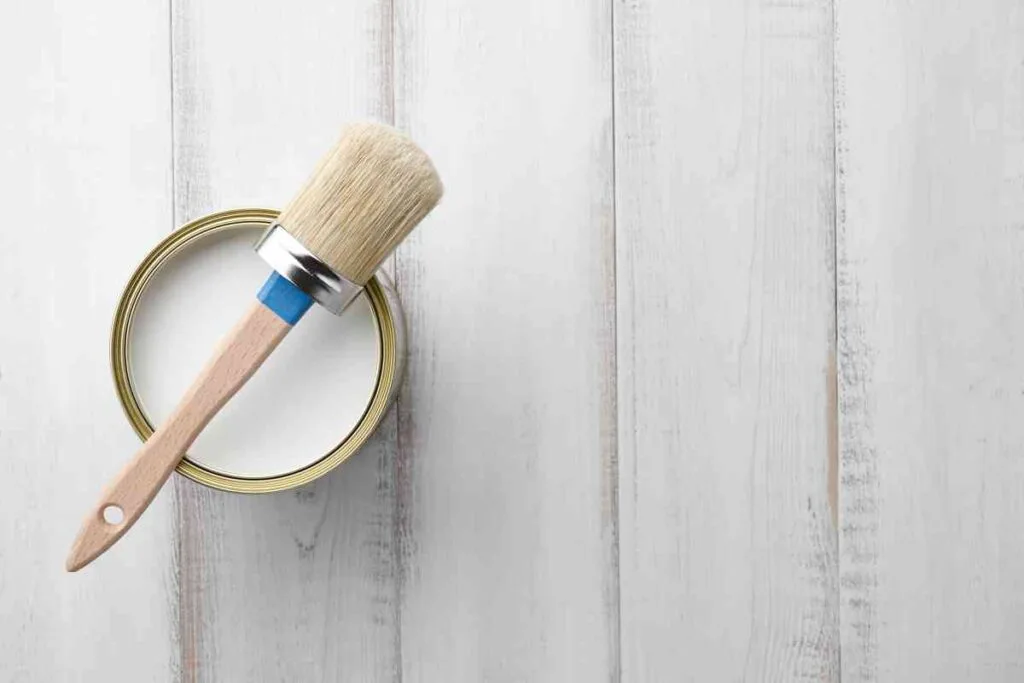 Can of chalk paint wax and wax brush on a white background