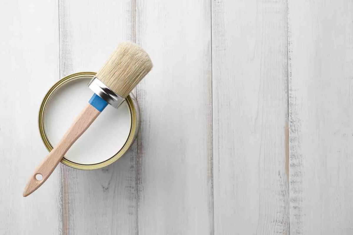 Can of chalk paint wax and wax brush on a white background