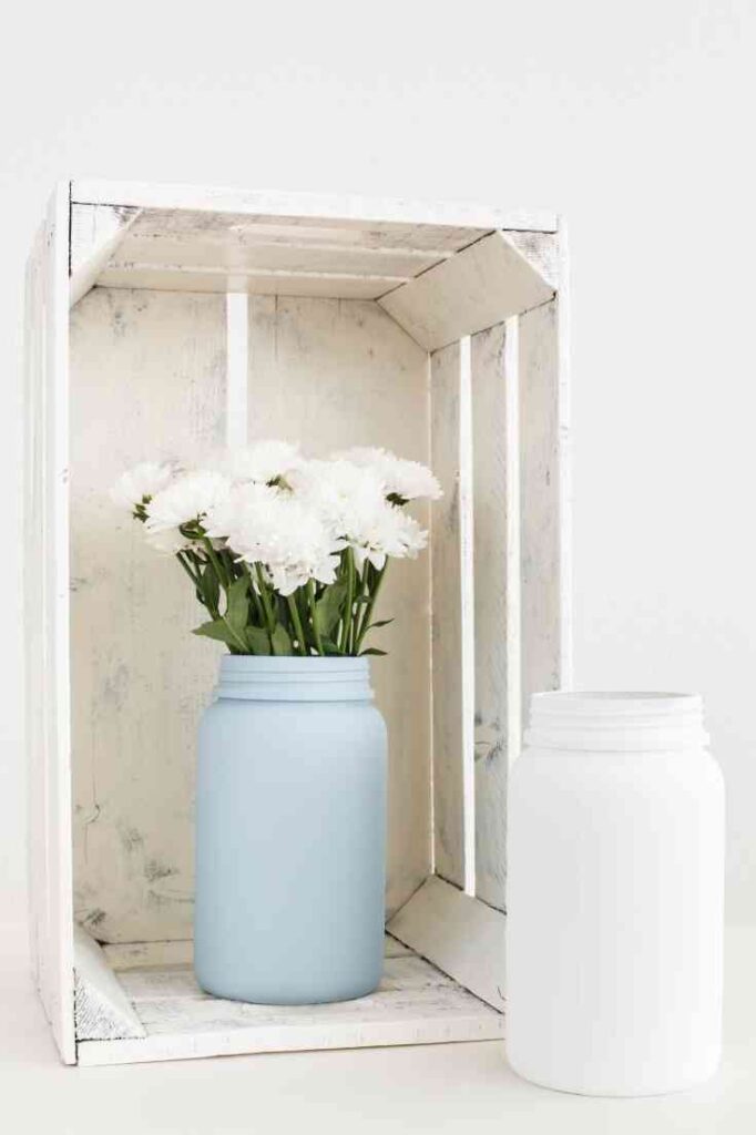 white crate and blue and white jars with white flowers