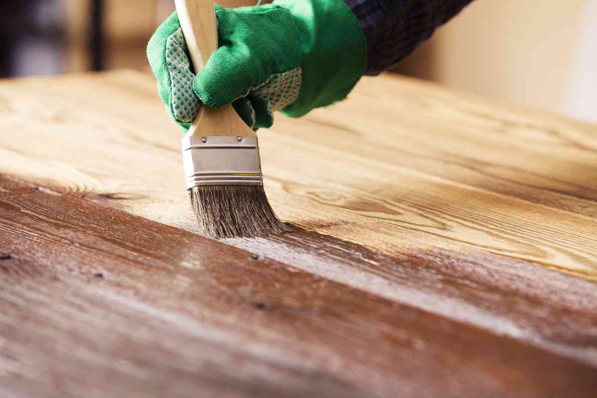 Using a paintbrush to apply the best stain for outdoor furniture