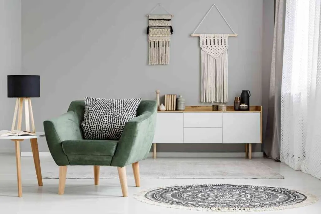 Room showcasing two macrame wall hangings with a green chair and white credenza