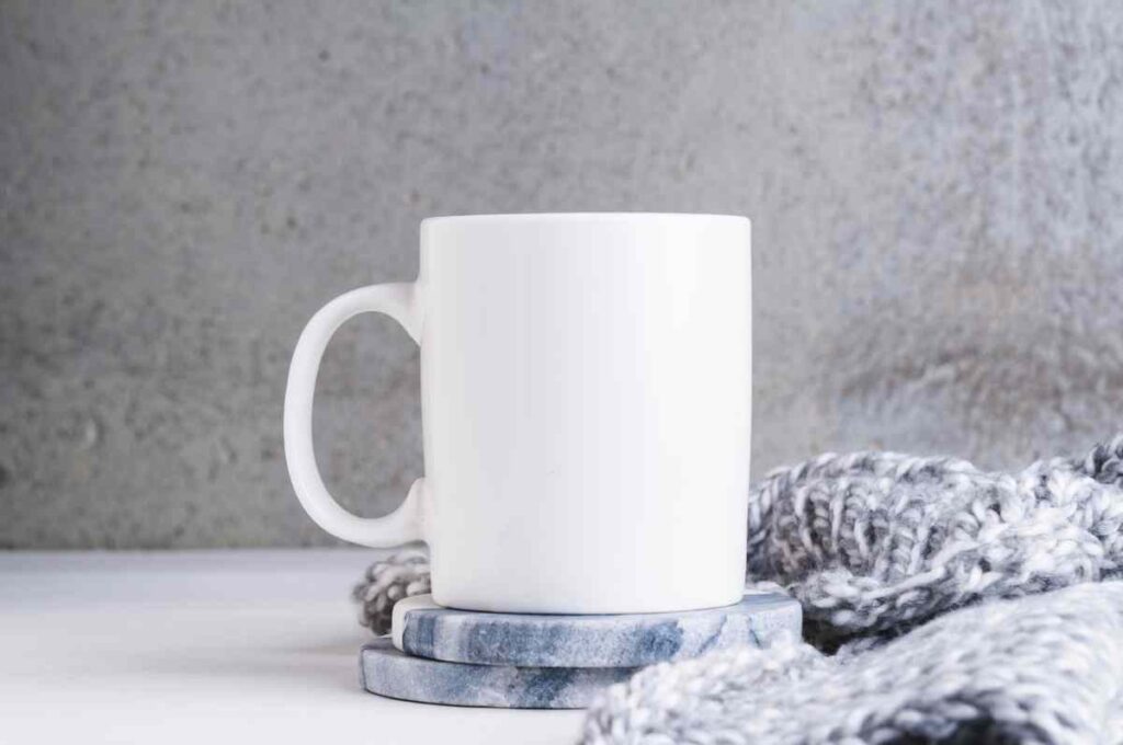 White coffee mug on blue and white painted coasters