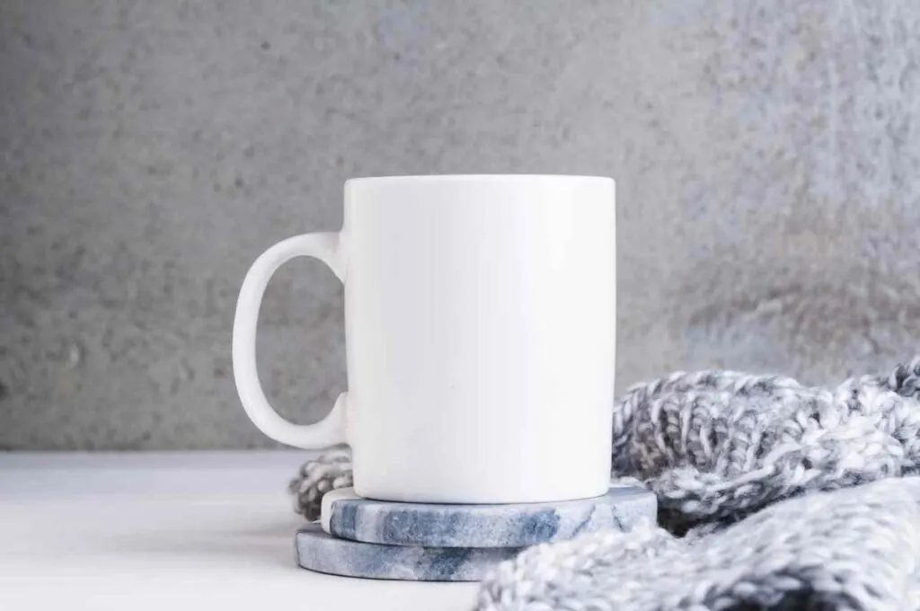 White coffee mug on blue and white painted coasters