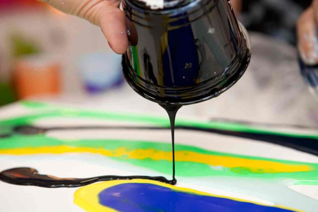 Person demonstrating  one of many paint pouring techniques
