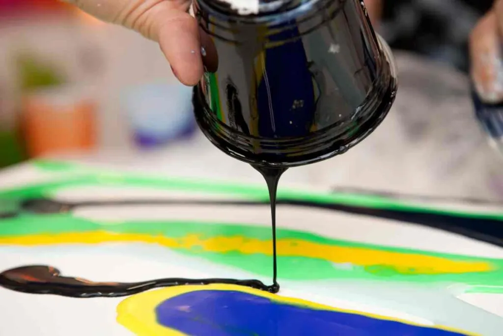 Person demonstrating one of many paint pouring techniques