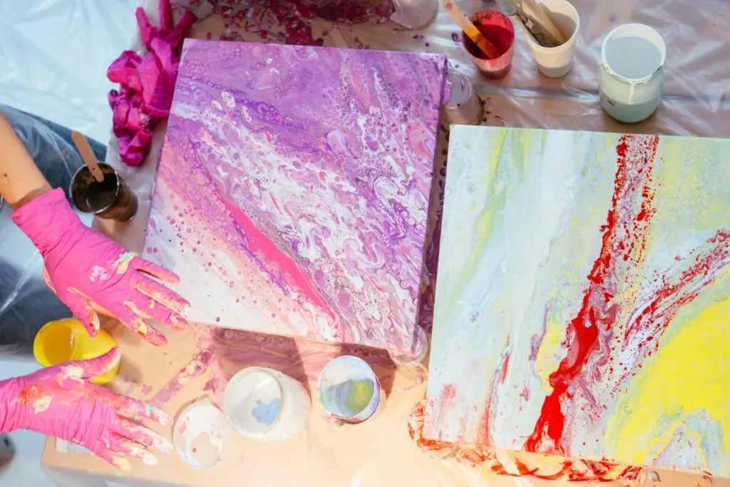 Two completed paint pouring canvases in various colors