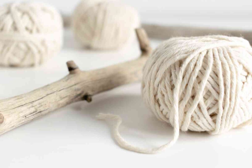 White cording and a stick used for macrame projects
