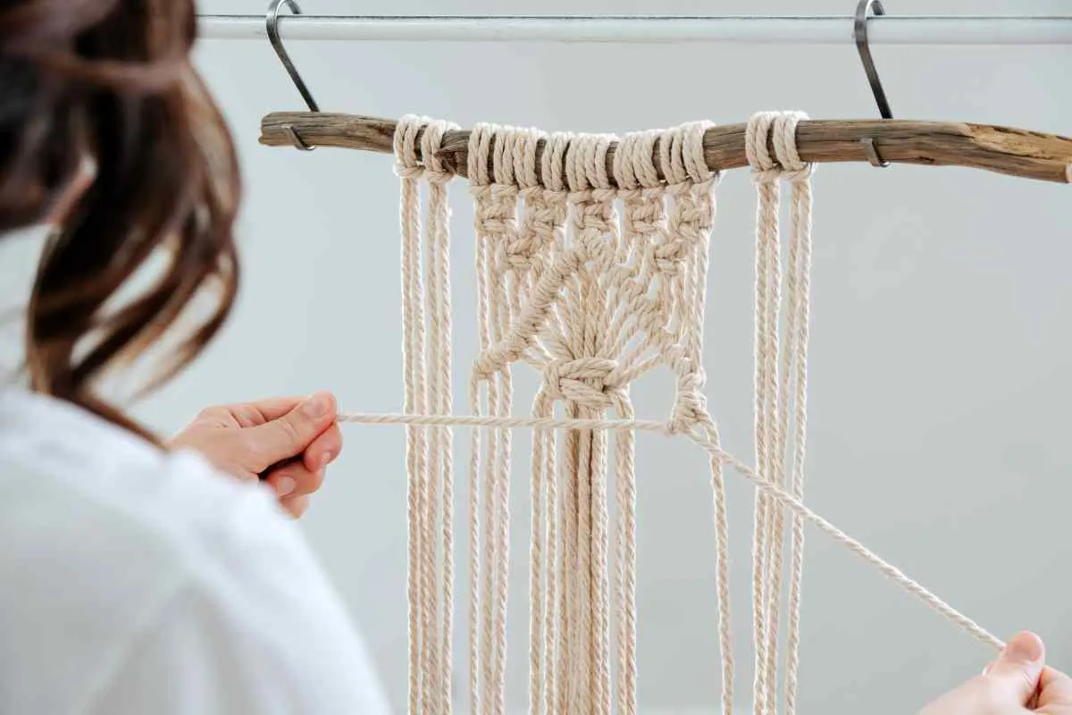 A woman showing how to make a macrame wall hanging