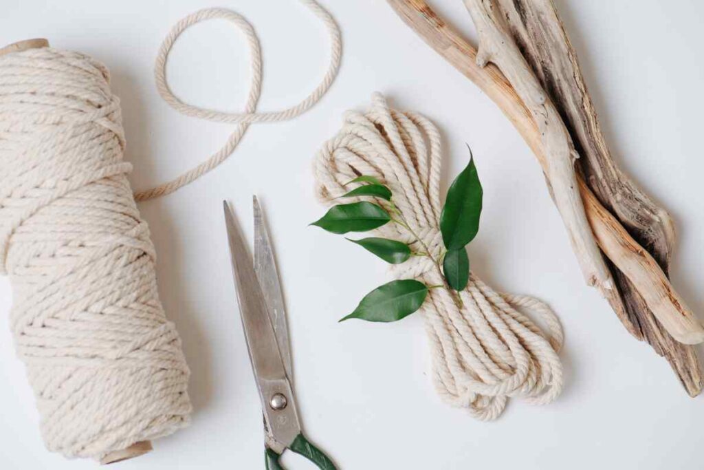 Close up of macrame cord, scissors, and other items need to create macrame projects