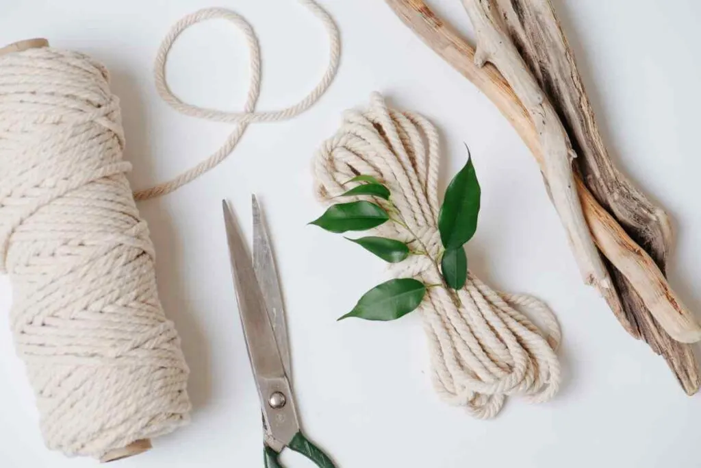 Close up of macrame cord, scissors, and other items need to create macrame projects