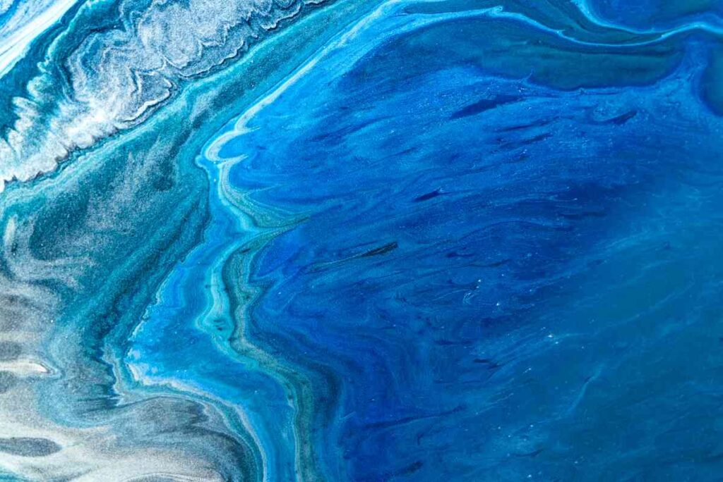 Paint pouring using blues reminiscent of the ocean